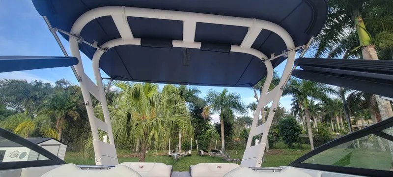 Slide: The Image of 2021 Regal LS2 boat with canopy, surrounded by lush palm trees. - 41