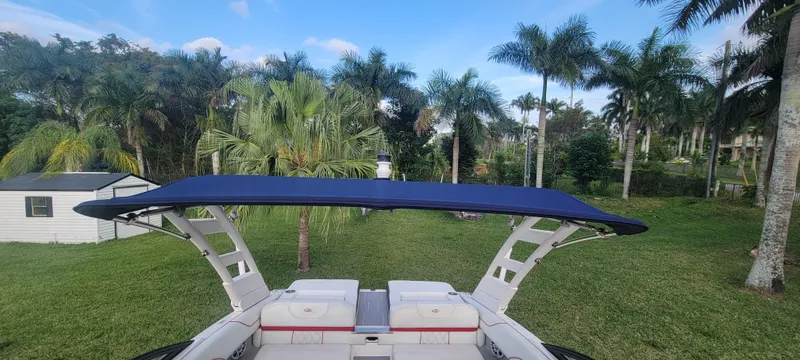 Slide: The Image of 2021 Regal LS2 boat with canopy, set in a lush, tropical landscape. - 42