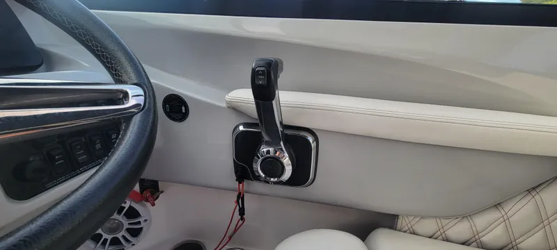Slide: The Image of Interior of a 2021 Regal LS2 boat showing steering wheel and throttle controls. - 46