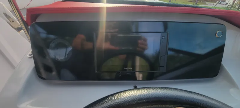 Slide: The Image of Dashboard of a 2021 Regal LS2 boat with steering wheel and control panel. - 48