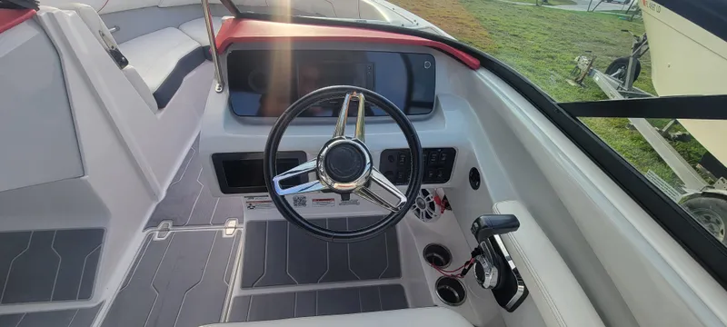 Slide: The Image of 2021 Regal LS2 boat cockpit with steering wheel and control panel. - 49