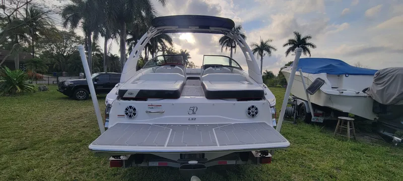 Slide: The Image of 2021 Regal LS2 boat with dual speakers, parked on grass near palm trees. - 7