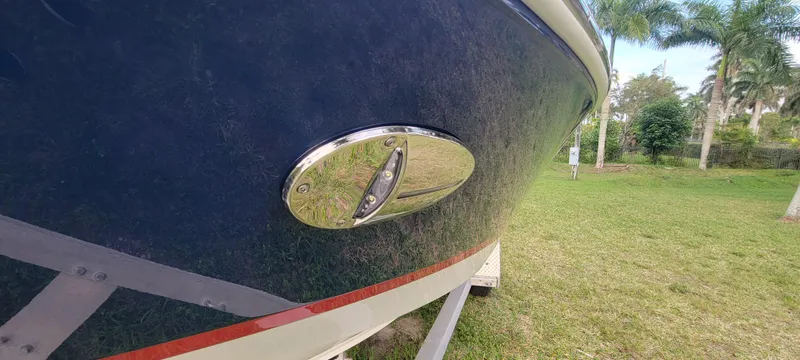Slide: The Image of 2021 Regal LS2 boat on trailer, close-up of hull detail, parked on grassy area. - 9