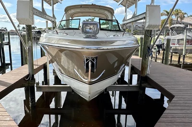 Slide: The Image of 2009 Formula 310 Bowrider boat docked on a lift in a marina. - 1