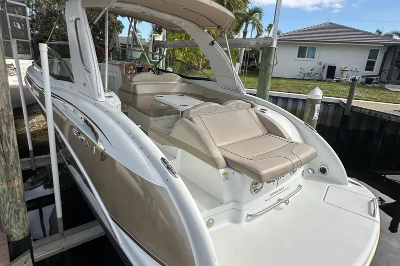 Slide: The Image of 2009 Formula 310 Bowrider boat with beige seating, docked near a residential area. - 5