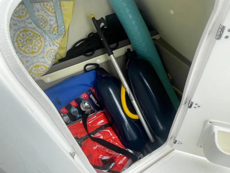 Slide: The Image of Storage compartment in 2020 Yamaha Boats 242 Limited S with boating accessories. - 12