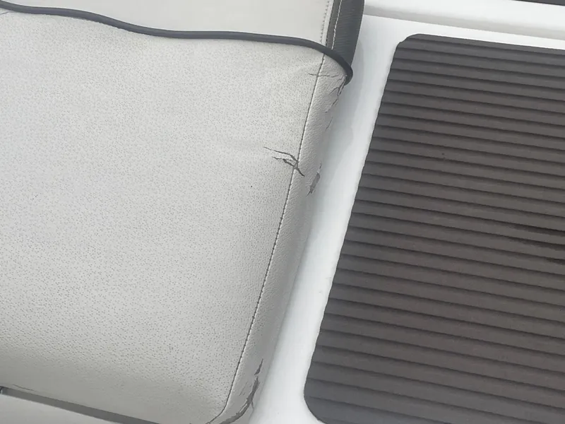 Slide: The Image of Torn upholstery on 2020 Yamaha Boats 242 Limited S seat with adjacent ribbed mat. - 20