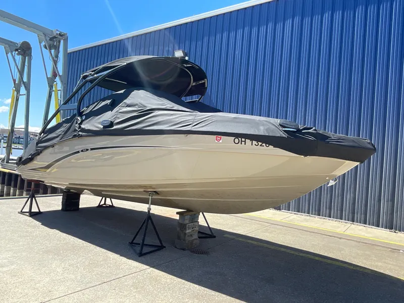 Slide: The Image of 2020 Yamaha Boats 242 Limited S covered and elevated on stands. - 3