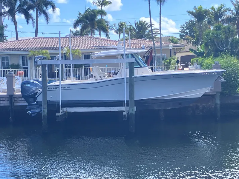 The Image of 2020 Grady-White Canyon 336 boat docked by waterfront home with palm trees. - 1