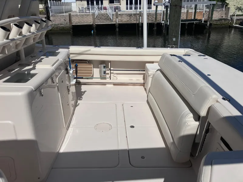 Slide: The Image of 2020 Grady-White Canyon 336 boat interior with seating and storage, docked by the water. - 15