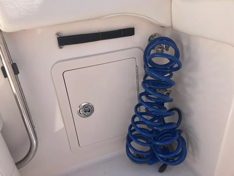 Slide: The Image of 2020 Grady-White Canyon 336 boat compartment with coiled blue hose. - 19