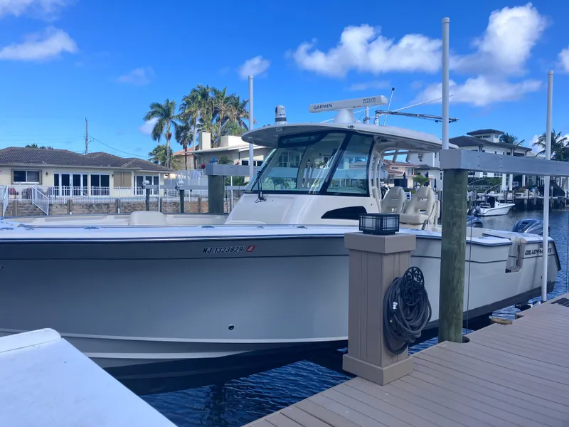 Slide: The Image of 2020 Grady-White Canyon 336 boat docked at marina under clear blue sky. - 3
