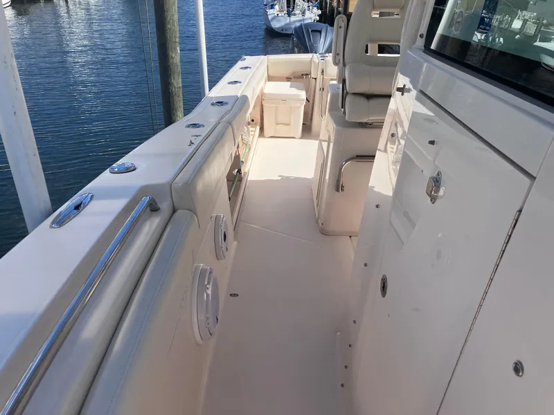 Slide: The Image of 2020 Grady-White Canyon 336 boat interior with seating and storage, docked by the water. - 35