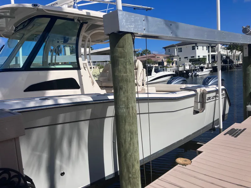 Slide: The Image of 2020 Grady-White Canyon 336 boat docked at marina under clear blue sky. - 4