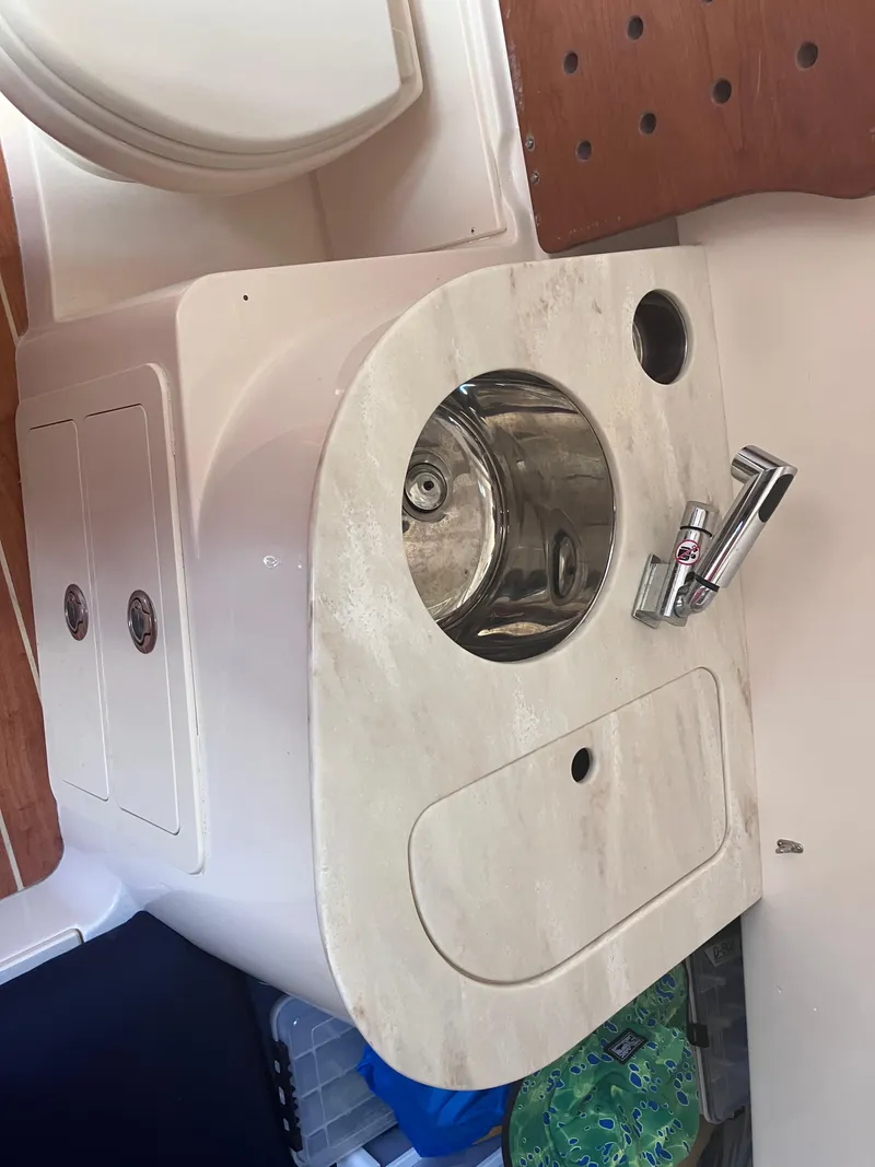 Slide: The Image of 2020 Grady-White Canyon 336 boat sink area with faucet and storage compartments. - 41