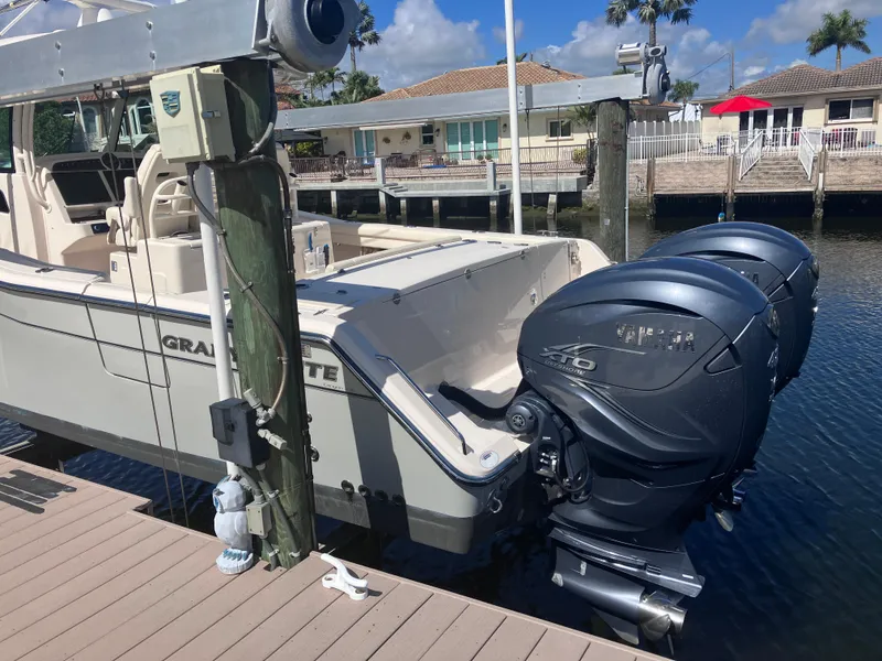 Slide: The Image of 2020 Grady-White Canyon 336 boat with dual Yamaha outboard engines docked by waterfront homes. - 5