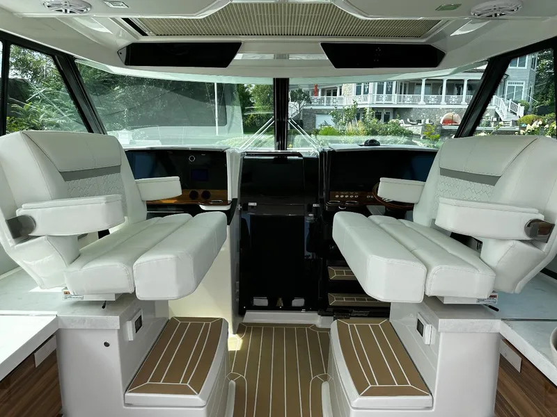 Slide: The Image of 2024 Tiara Yachts 43 LE interior with luxurious white seating and modern dashboard. - 10
