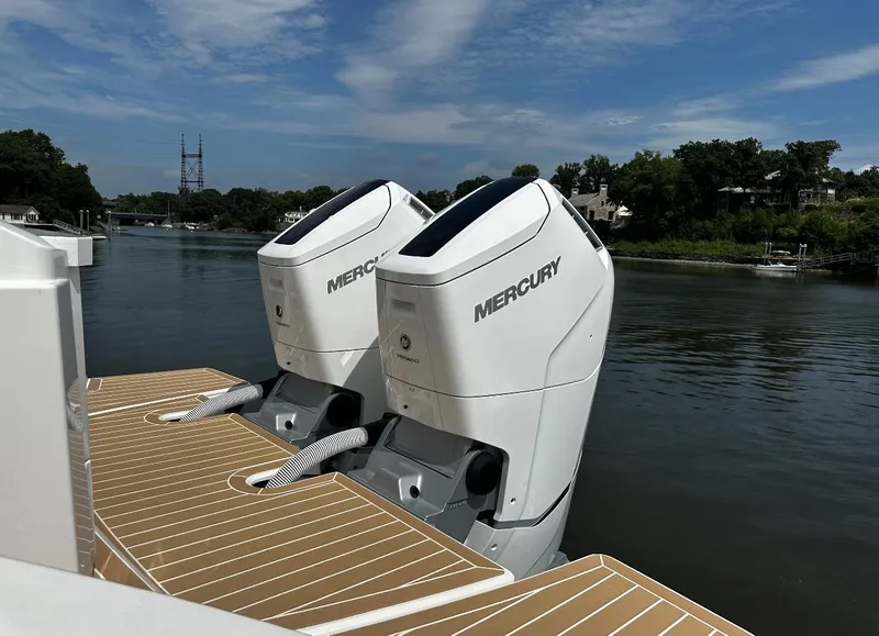 Slide: The Image of 2024 Tiara Yachts 43 LE with dual Mercury outboard engines on a serene river. - 14