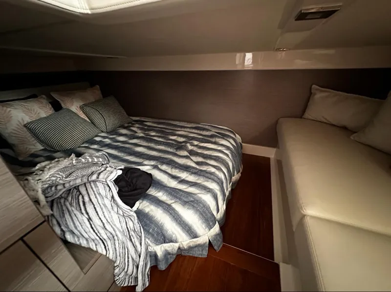 Slide: The Image of 2024 Tiara Yachts 43 LE cabin with cozy bed and seating area. - 17