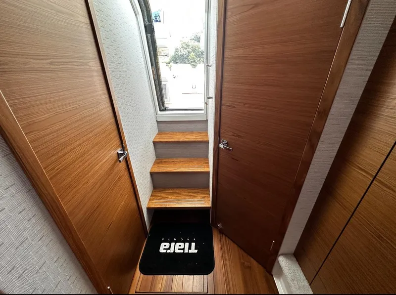 Slide: The Image of 2024 Tiara Yachts 43 LE interior with wooden steps and sleek design. - 21