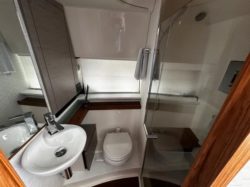 Slide: The Image of 2024 Tiara Yachts 43 LE bathroom with modern sink, toilet, and glass shower. - 25