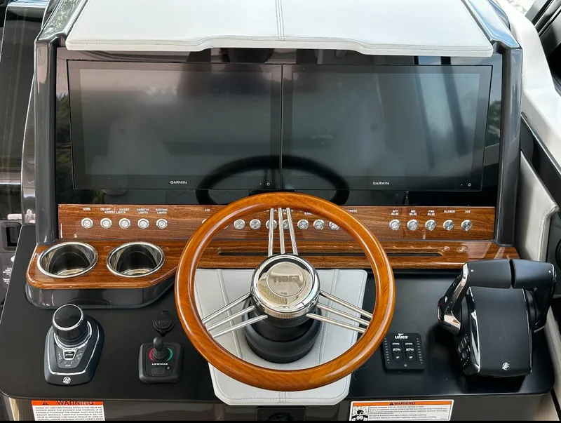 Slide: The Image of 2024 Tiara Yachts 43 LE helm with dual screens and wooden steering wheel. - 3