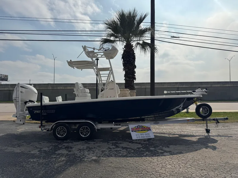 The Image of 2025 Pathfinder 2500 Hybrid boat on trailer, parked outdoors near palm tree. - 0