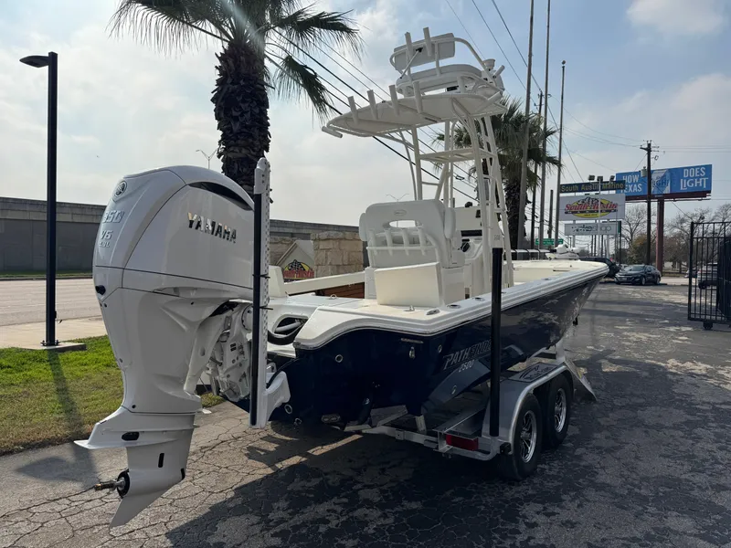 Slide: The Image of 2025 Pathfinder 2500 Hybrid boat on trailer, featuring Yamaha outboard motor, parked near palm trees. - 2