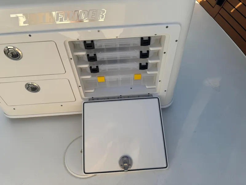 Slide: The Image of Pathfinder 2500 Hybrid 2025 boat storage compartments with open hatch and tackle boxes. - 21