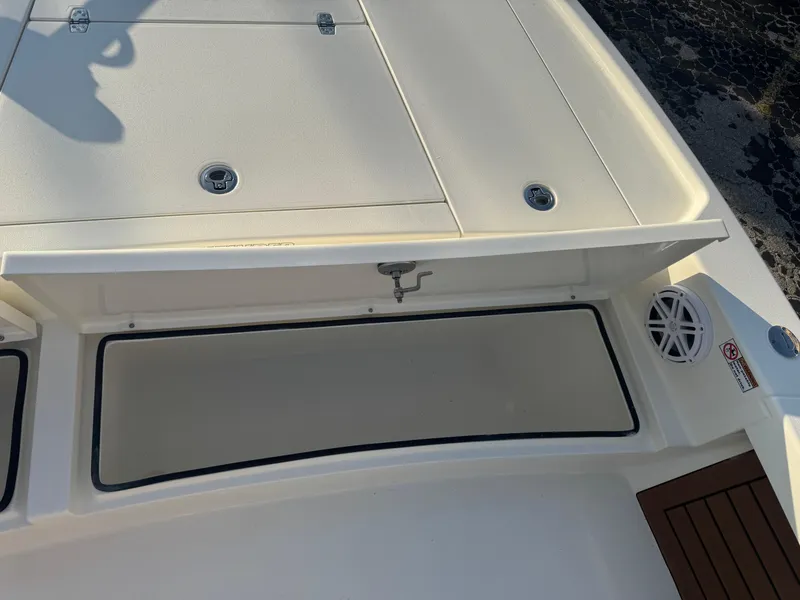 Slide: The Image of 2025 Pathfinder 2500 Hybrid boat storage compartment with open lid and speaker. - 30