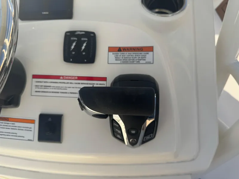 Slide: The Image of Control panel of 2025 Pathfinder 2500 Hybrid boat with throttle and warning labels. - 6