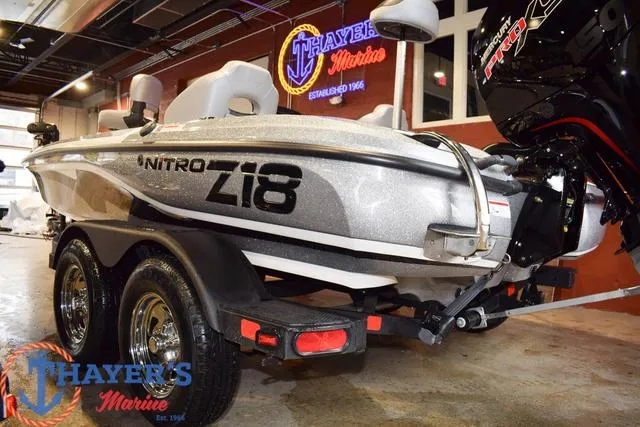 Slide: The Image of 2025 Nitro Z18 Pro boat in showroom, featuring sleek design and dual-axle trailer. - 5