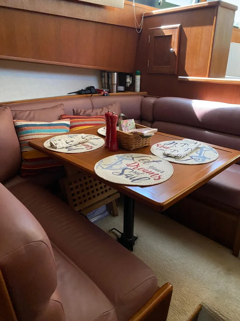 Slide: The Image of Cozy dining area in a 1990 Viking 45 Convertible yacht with nautical-themed decor. - 16