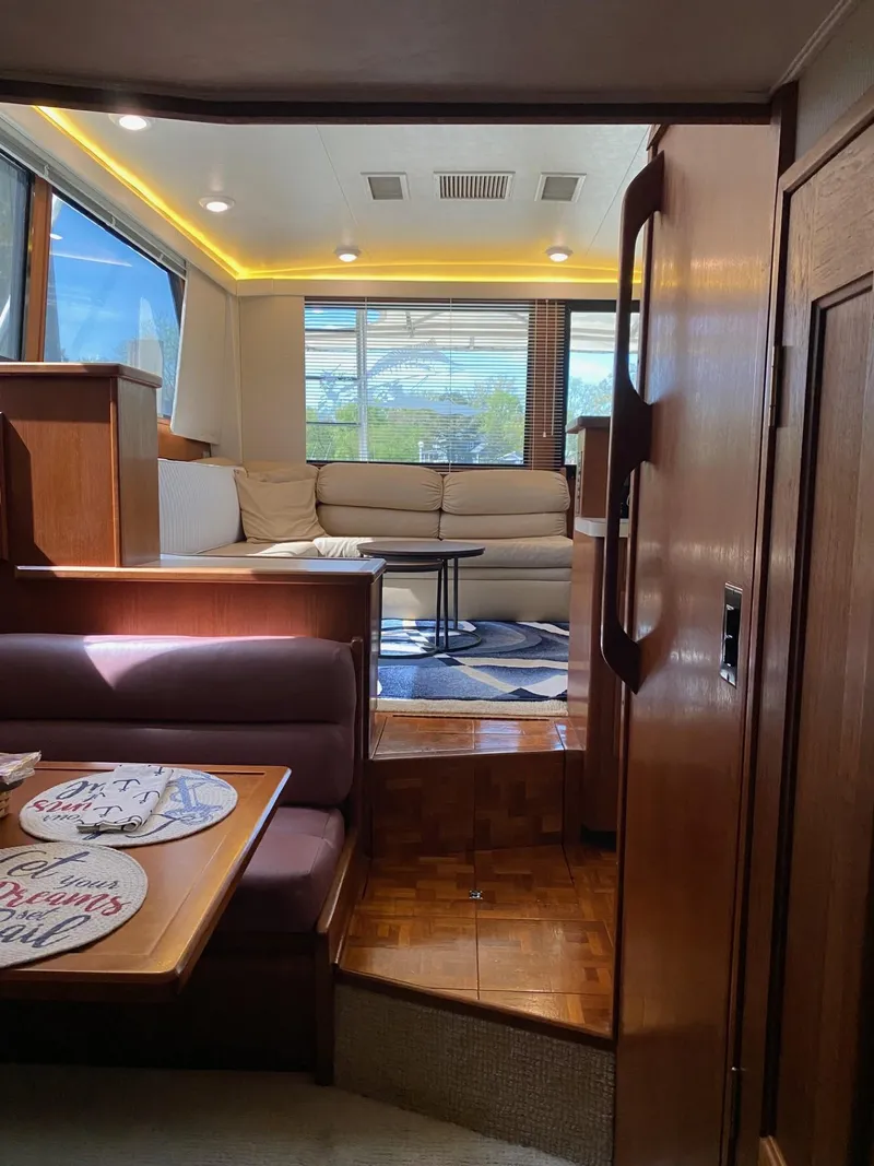 Slide: The Image of Interior of a 1990 Viking 45 Convertible yacht with cozy seating and elegant wood finishes. - 17