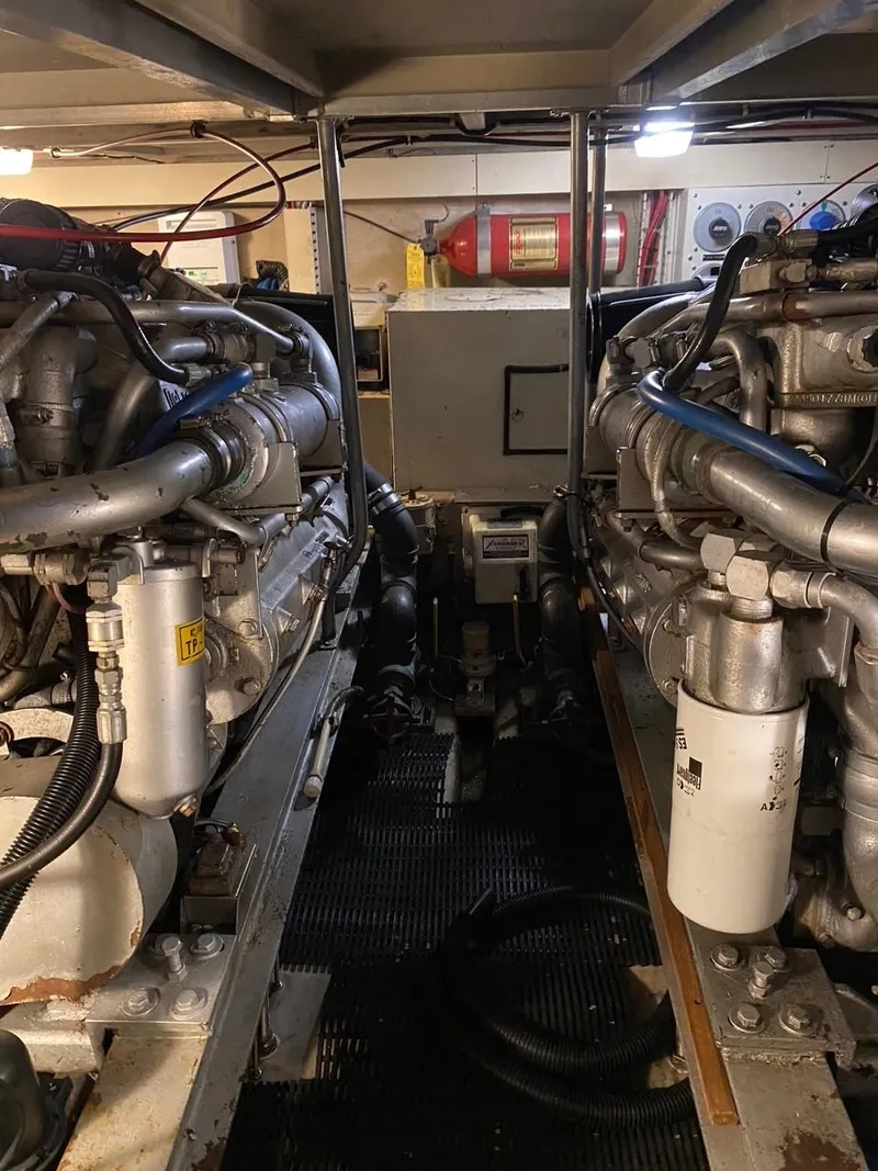 Slide: The Image of Engine room of a 1990 Viking 45 Convertible boat, showcasing dual engines and mechanical components. - 23