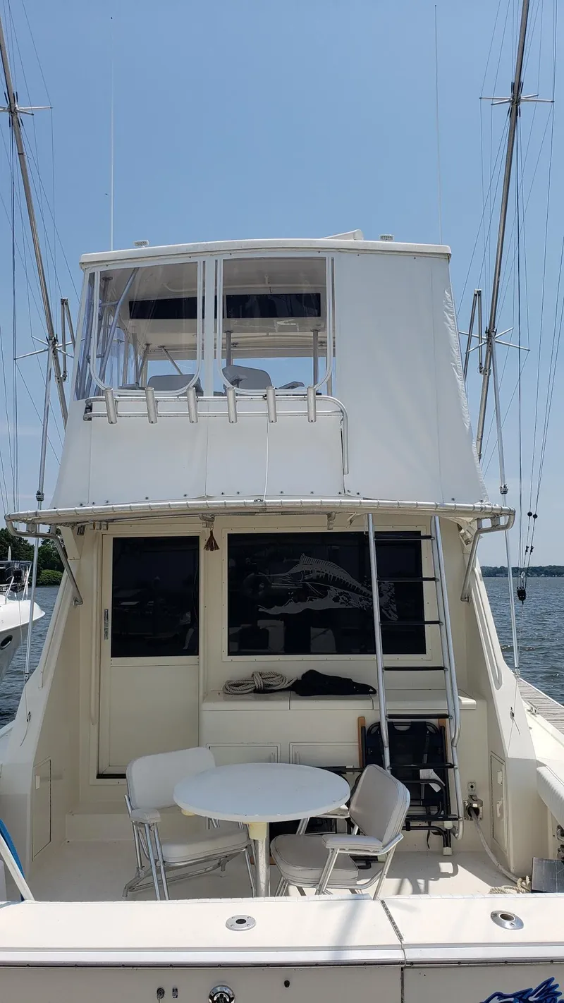 Slide: The Image of 1990 Viking 45 Convertible yacht with outdoor seating, docked on a sunny day. - 6