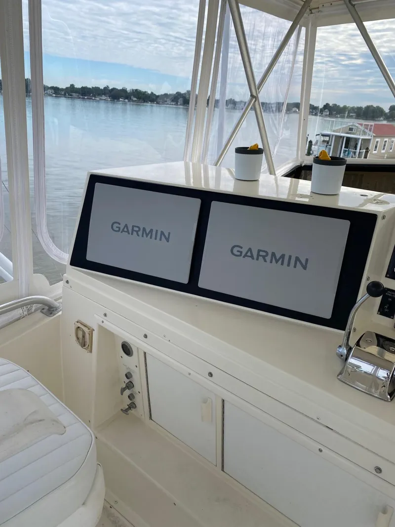 Slide: The Image of Viking 45 Convertible 1990 boat helm with dual Garmin displays, overlooking serene waters. - 8