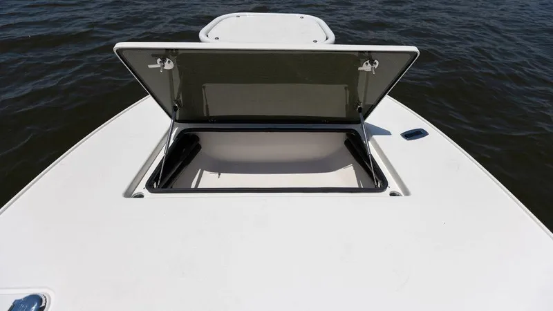 Slide: The Image of Open storage compartment on 2024 Sterling 180TS boat deck, with water in the background. - 13