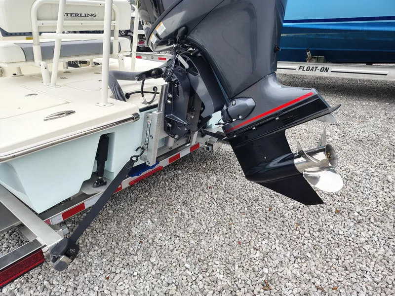 Slide: The Image of 2024 Sterling 180TS boat with outboard motor on a trailer, parked on gravel. - 9