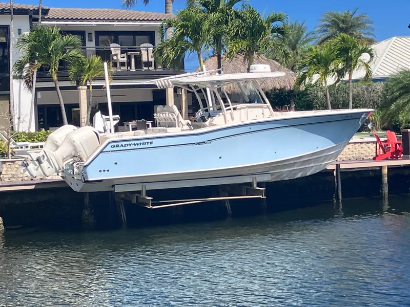 The Image of 2018 Grady-White Canyon 336 boat docked by waterfront home with palm trees. - 1