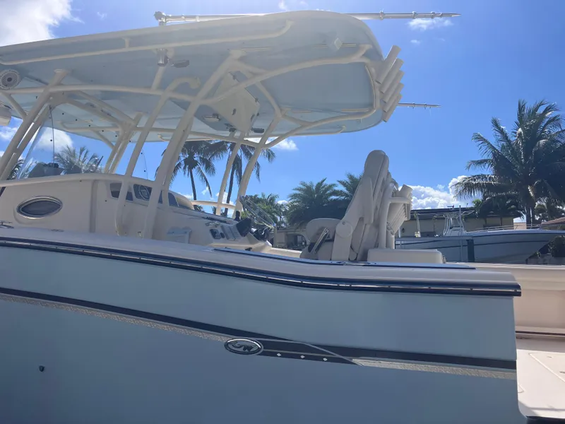 Slide: The Image of 2018 Grady-White Canyon 336 boat with T-top, docked under clear blue sky. - 13