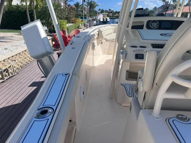 Slide: The Image of 2018 Grady-White Canyon 336 boat interior with helm and seating, docked by a waterfront. - 27