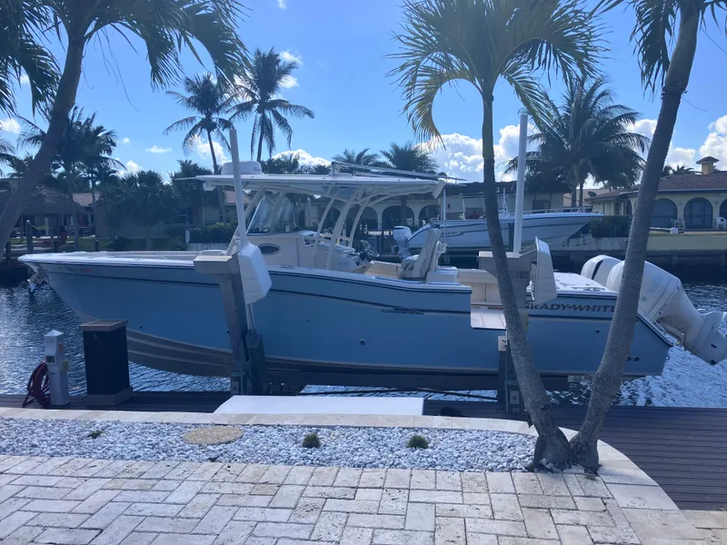 Slide: The Image of 2018 Grady-White Canyon 336 boat docked by palm trees, sunny waterfront setting. - 4