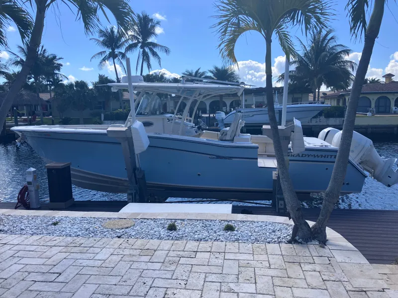 Slide: The Image of 2018 Grady-White Canyon 336 boat docked by palm trees, sunny waterfront setting. - 5