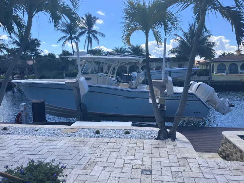 Slide: The Image of 2018 Grady-White Canyon 336 boat docked by palm trees, sunny waterfront setting. - 6