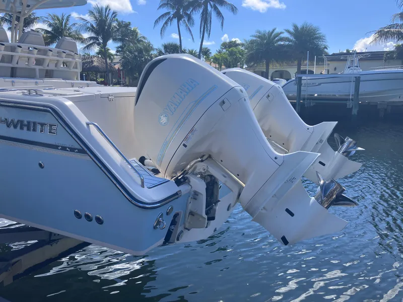 Slide: The Image of 2018 Grady-White Canyon 336 boat with twin outboard engines docked by palm trees. - 7