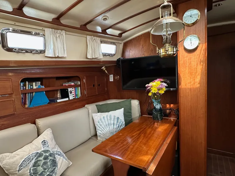 Slide: The Image of Cozy interior of 1983 Whitby 42 Ketch with wood paneling and nautical decor. - 10