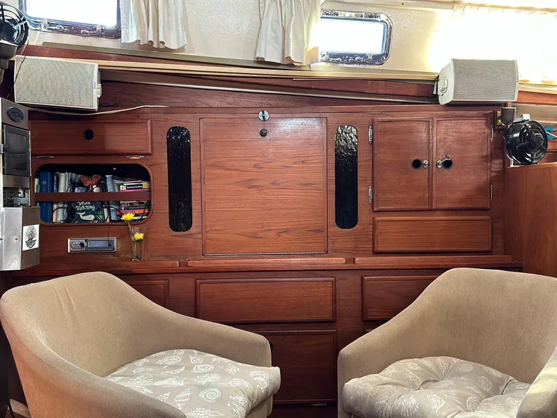 Slide: The Image of Interior of 1983 Whitby 42 Ketch with wooden cabinetry and two beige chairs. - 11
