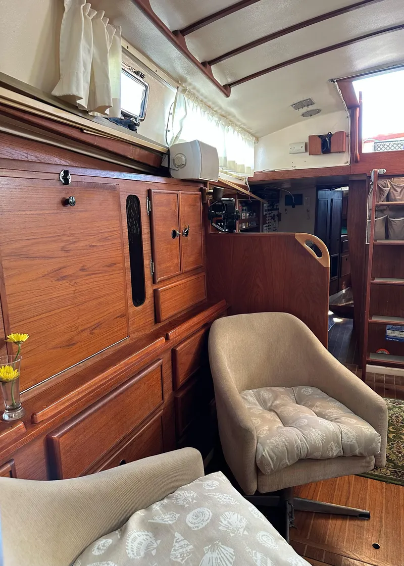 Slide: The Image of Interior of 1983 Whitby 42 Ketch sailboat with wooden cabinetry and cozy seating. - 13