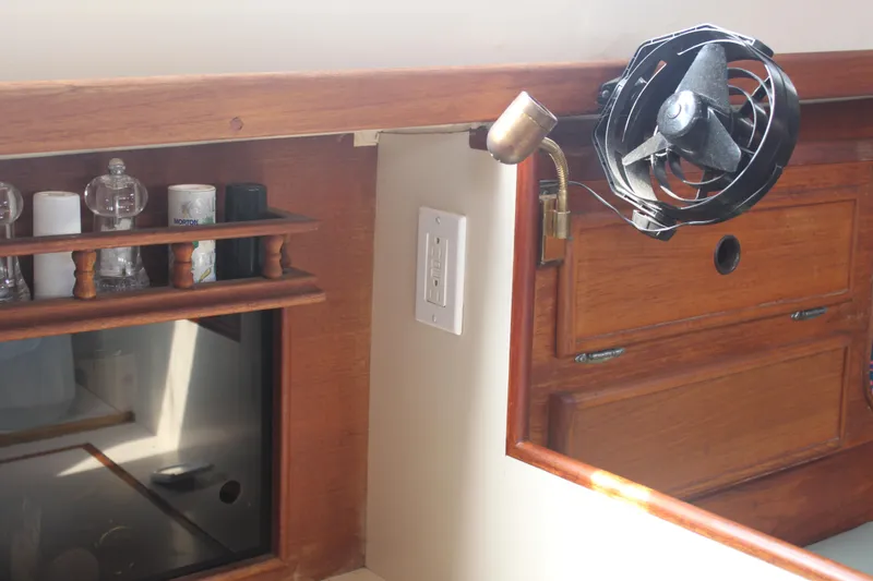 Slide: The Image of 1983 Whitby 42 Ketch interior with wooden cabinetry, fan, and spice rack. - 17